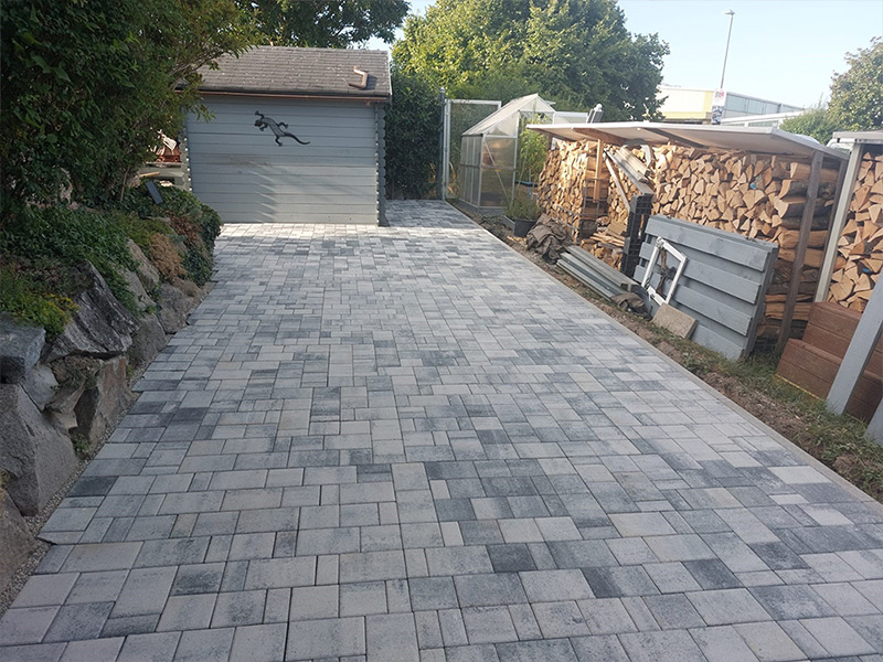 Außenanlage mit Unterbau, Pflaster und Granit Stele gestaltet